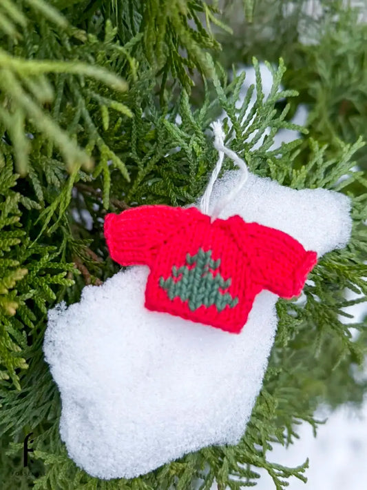 Rød mini genser med juletre motiv opp på snø i tre
